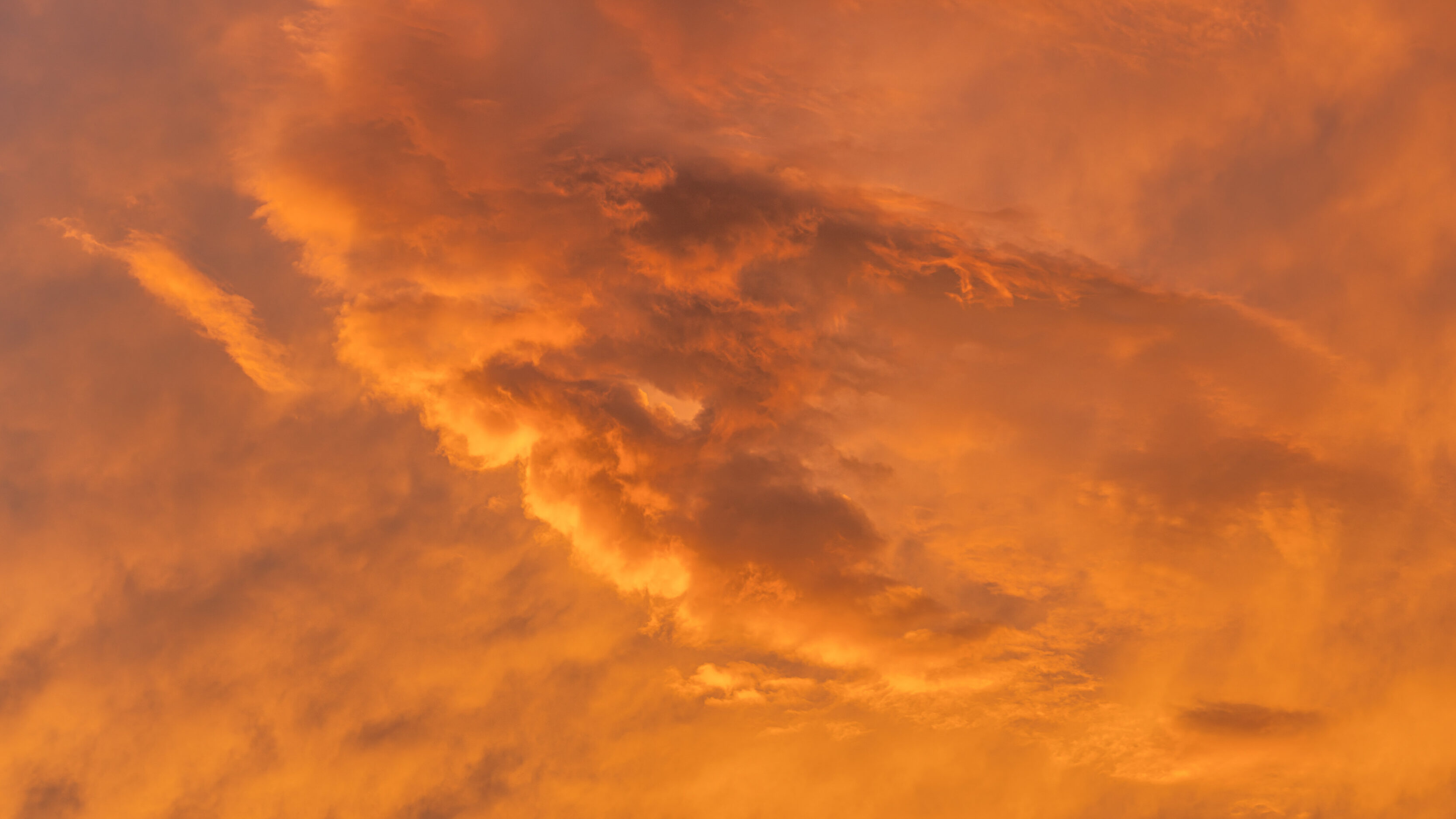 Orange sunset sky with fiery clouds and hazy light across the horizon a warm glow.